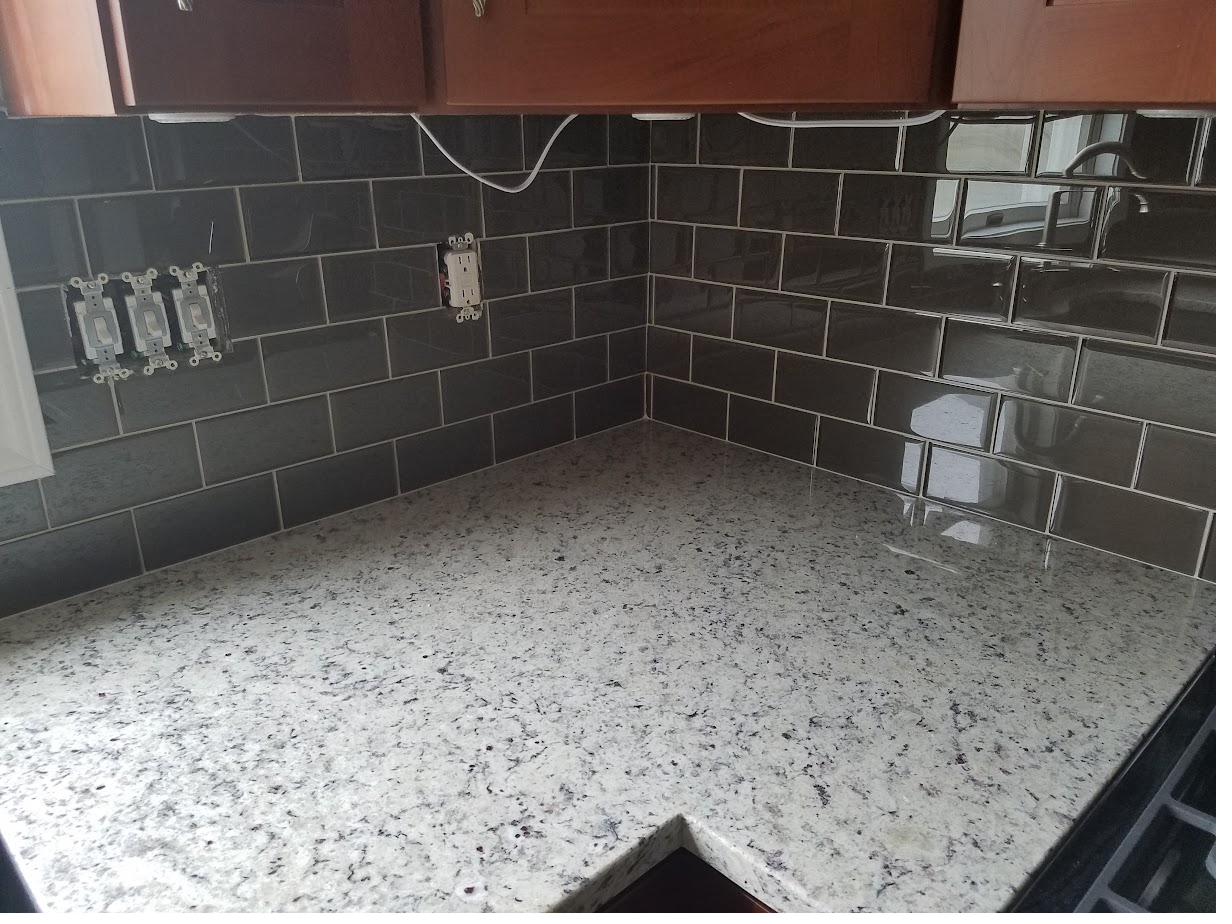 Glass subway tile backsplash with granite counters